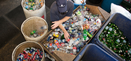 Photo of a person sorting beverage containers into different bins