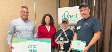 2023 award winner accepting their award with 2 divert ns staff