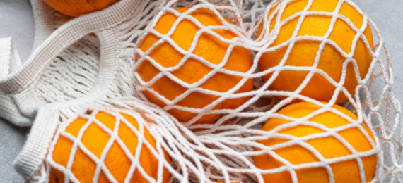 oranges in a woven reusable bag