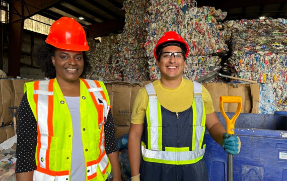 2 interns standing infront of bales of recycling