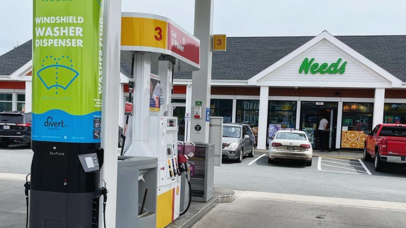 a gas station with a windshield washer fluid dispenser system next to a pump