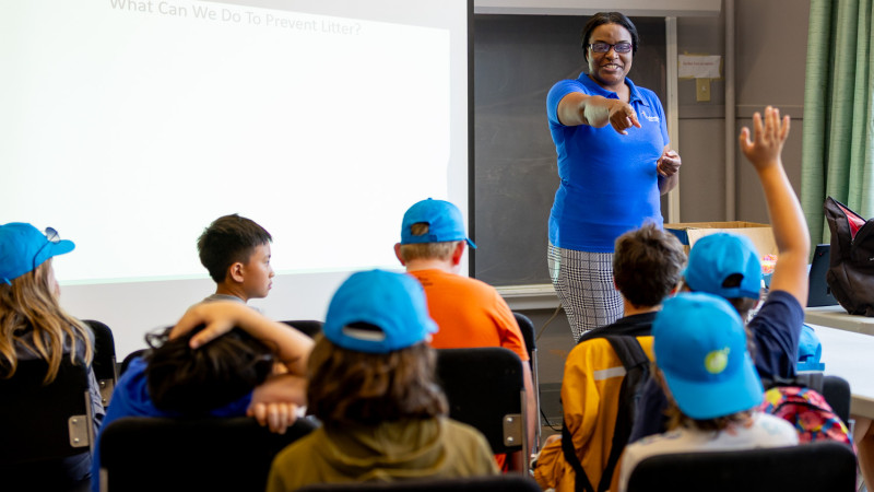 educator in classroom pointing at student with hand up