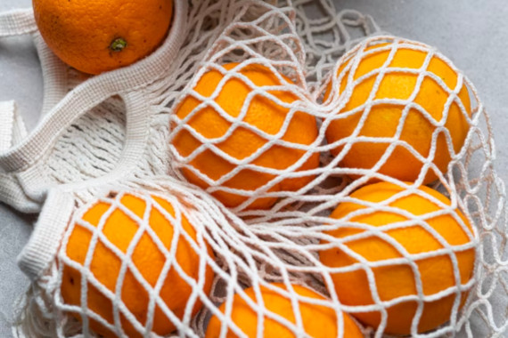 oranges in a woven reusable bag