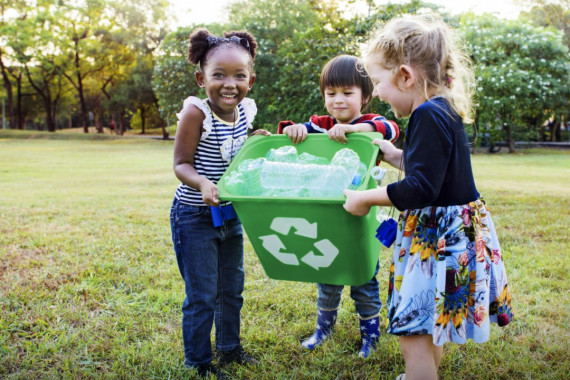 children holding a recycling bin