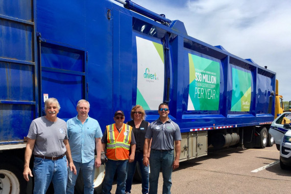 people standing beside a recycling truck