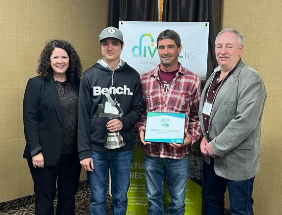 award winner accepting his award with 2 divert ns staff