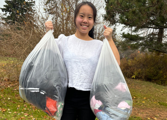 Young girl holding up garbage bags