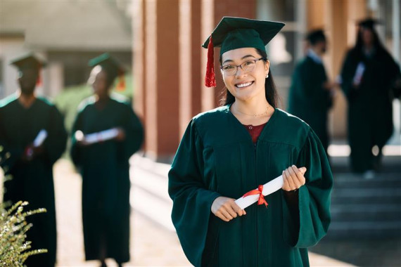 happy asian female student with bachelors degree
