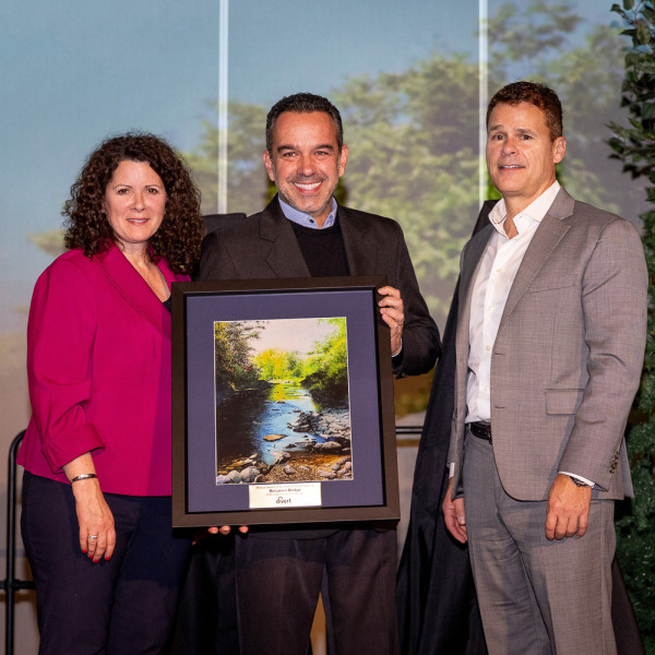 3 people posing for the camera, holding the award